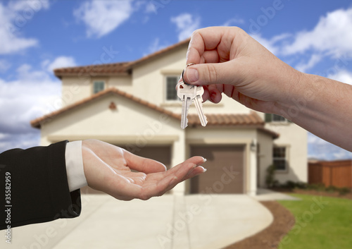 Photo: Handing Over the House Keys in Front of New Home Handing Over the House Keys in Front of New Home