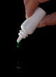 Sidelit bright green eye or ear drops fall from dropper bottle