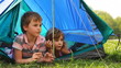 Boy with girl lay peeping out of tent