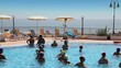 Tourists make waterobics in pool near beach