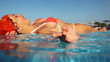 Woman lies on pools partition and mixes water