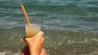 Hand rests on knee and holding glass with cocktail