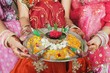 Indian girls holding a decorated mehendi /henna plate.