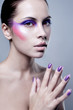 Photo: Portrait of attractive young woman with colorful makeup on face Portrait of attractive young woman with colorful makeup on face