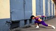 Girl dances in modern style near building