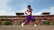 Woman performs modern dance, at background of small wall
