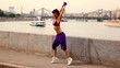 Flexible girl actively dances on quay