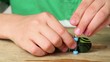 Boy fasten one wheel tightly to fingerskate using tool