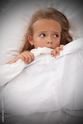 Photo: Little girl in bed awaken by nightmares Little girl in bed awaken by nightmares