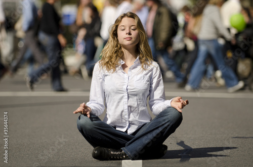 Photo: woman meditating in busy urban street woman meditating in busy urban street