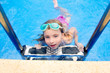 blond little girl in swimming pool with goggles