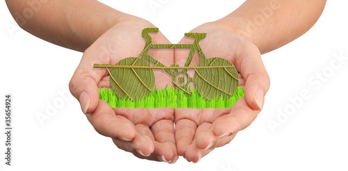 Photo: Hand hold a green bicycle made from leave Hand hold a green bicycle made from leave