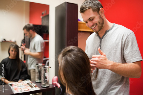 Foto: Smiling male hairdresser cutting hair Smiling male hairdresser cutting hair