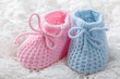Blue and pink baby booties on white background