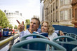 A couple sitting on a  bus, admiring the view