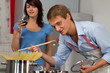 Photo: Happy young couple in the kitchen cooking dinner Happy young couple in the kitchen cooking dinner