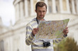 A man standing in front of St Paul's cathedral with a map