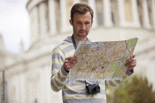 Photo: A man standing in front of St Paul's cathedral with a map A man standing in front of St Paul's cathedral with a map