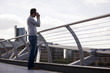 A man on the Millennium Bridge, taking a photograph