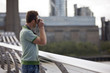 A man on the Millennium Bridge, taking a photograph
