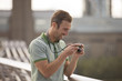 A  man looking at his photographs on his camera