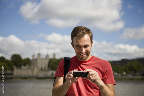 Foto: A man looking at his photographs on his phone A man looking at his photographs on his phone