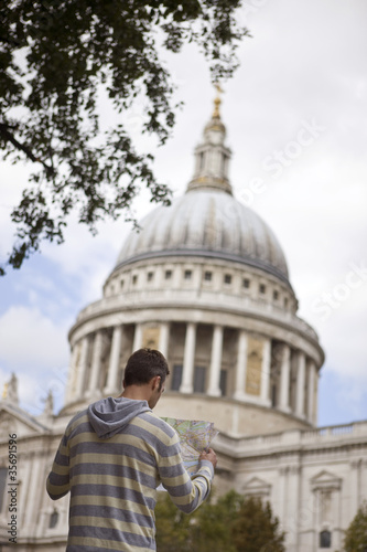Photo: A man in front of St Paul's cathedral, looking at a map A man in front of St Paul's cathedral, looking at a map