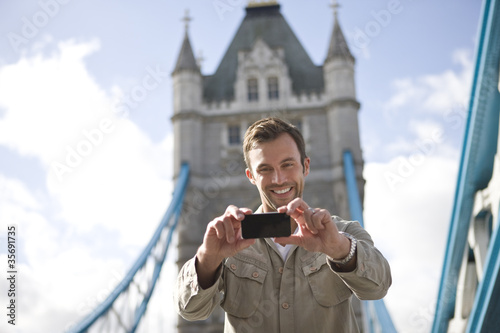 Photo: A man taking a photograph of himself in front of Tower Bridge A man taking a photograph of himself in front of Tower Bridge