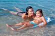 Swimming lesson. Little girl and her mother swimming in the sea.