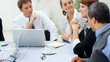 Business woman speaking in meeting with multi racial colleagues