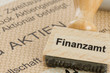 Stempel mit Aufschrift Finanzamt auf einer Aktie