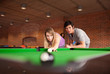 Man teaching pool to his girlfriend
