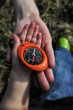 Compass in a child hand with mother supporting palm