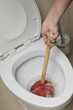homme débouchant WC avec ventouse