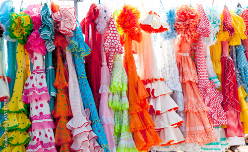 Photo: colorful gipsy dresses in rack hanged in Spain colorful gipsy dresses in rack hanged in Spain