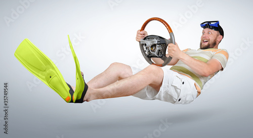 Photo: Curious man in flippers and shorts with a wheel Curious man in flippers and shorts with a wheel