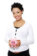 Pregnant woman holding piggy bank