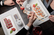 A pair, a man and a woman, eating maki sushi roll with chopstick