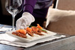 Potato pancakes served by a waiter in white gloves