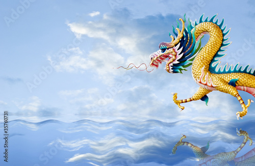 Foto: Golden dragon flying over the sea with nice sky background Golden dragon flying over the sea with nice sky background