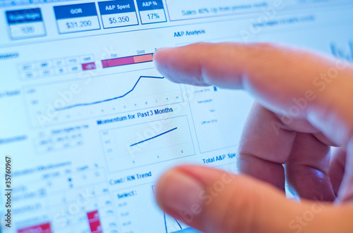 Foto: finger touching graph on screen finger touching graph on screen