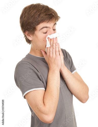 Photo: sick young man with flu blowing her nose, series sick young man with flu blowing her nose, series