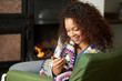 Young woman sitting by fire with phone