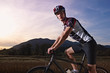 Photo: portrait of man training on mountain bike at sunset portrait of man training on mountain bike at sunset