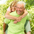 happy senior man giving piggyback senior woman happy senior man giving piggyback senior woman
