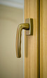 Photo: Gold window handle on laminated frame Gold window handle on laminated frame