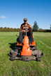 Mature man driving grass cutter