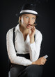 Photo: Woman in black hat with cigar in black background isolated Woman in black hat with cigar in black background isolated