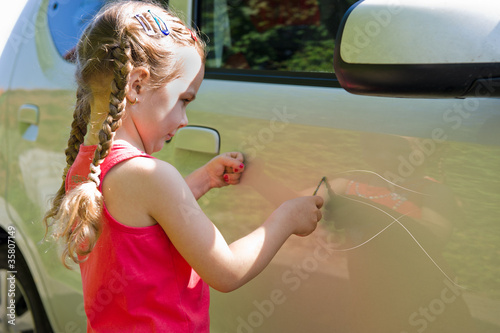 Kind  verkratzt ein Auto