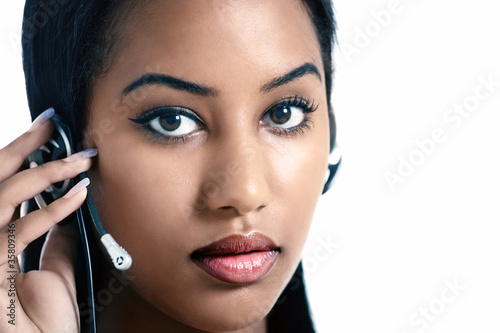Photo: Serious office worker listening on headset Serious office worker listening on headset